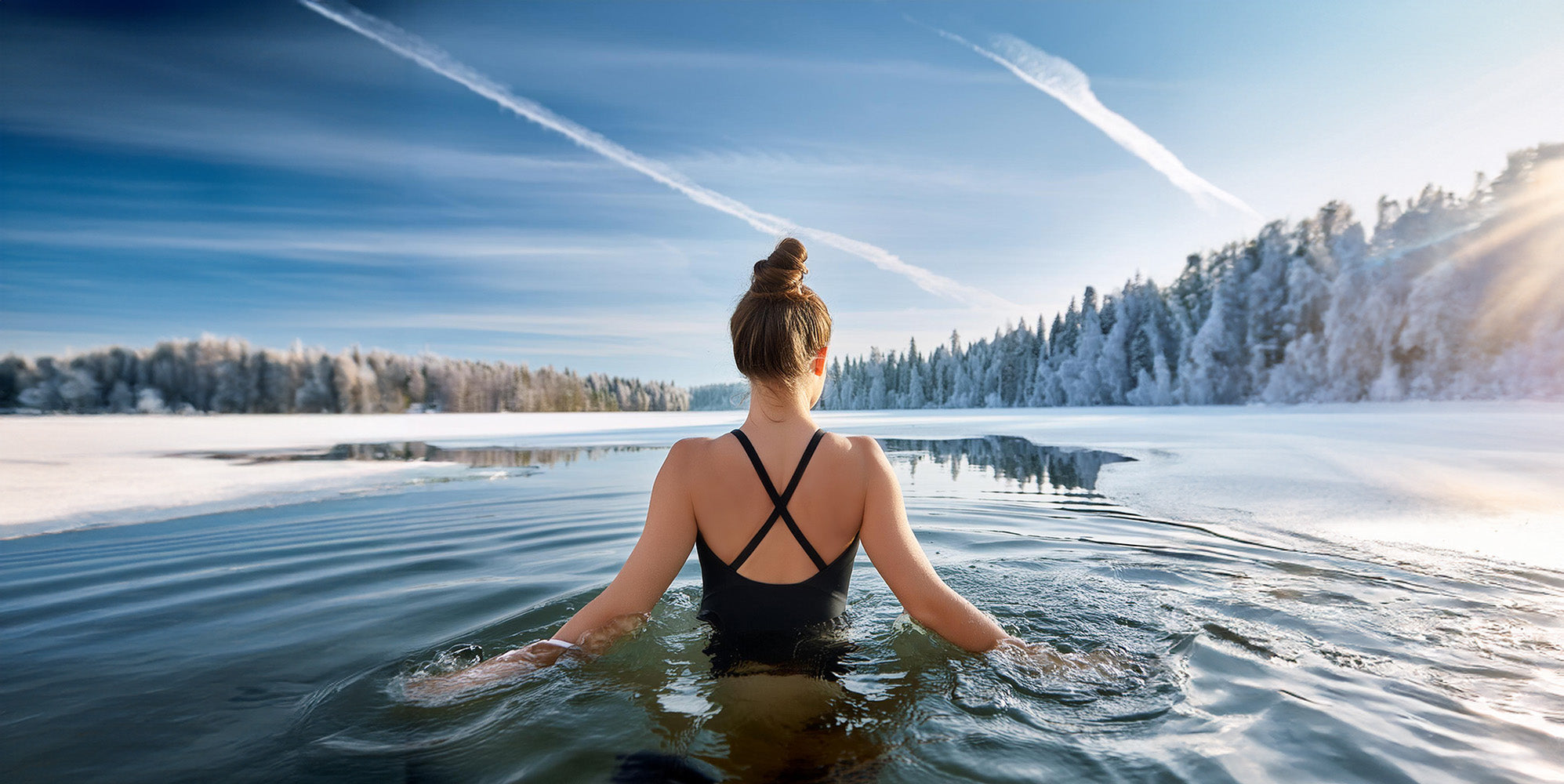 Woman walking into a lake with the morning light on right side